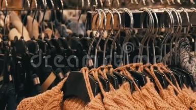 时尚的暖衣收藏.. 挂在衣架上的各种颜色的新型温暖时尚毛衣数量众多